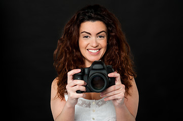 Image showing Cheerful woman holding newly launched camera