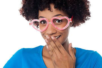 Image showing Young model in heart shaped frame stifling her giggle