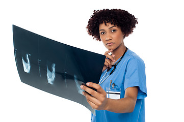 Image showing Young serious lady surgeon holding x-ray sheet