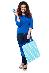 Image showing Shopaholic woman holding shopping bags and credit card