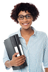 Image showing Bespectacled woman in casuals holding files