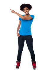 Image showing Attractive young woman pointing sideways