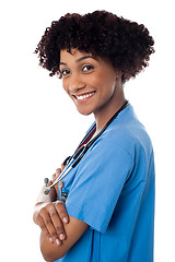 Image showing Smiling female physician standing sideways with folded arms