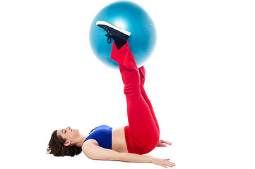 Image showing Fit woman holding exercise ball between legs