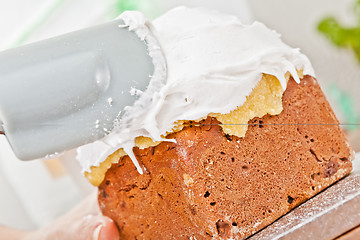 Image showing Spreading cream on cake icing