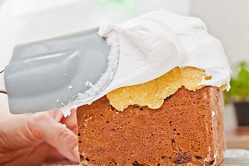 Image showing Spreading cream on cake icing