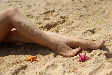 Image showing Beautiful female legs on the beach 