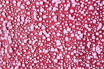 Image showing Pink pimples on a red background