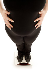 Image showing pregnant lady weighing oneself, focus on belly