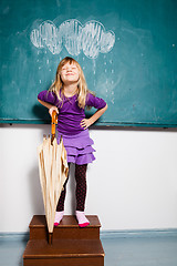 Image showing Smiling young girl with umbrella indoors