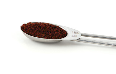 Image showing Ground cloves measured in a metal teaspoon