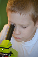 Image showing the boy looks in a microscope