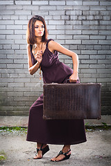 Image showing beautiful thief girl with vintage suitcase waiting at the station