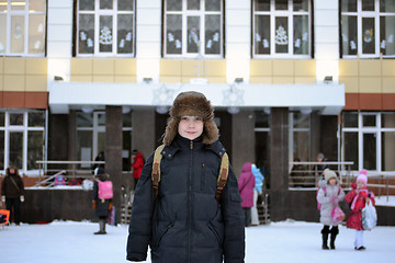 Image showing The boy costs against school in the winter