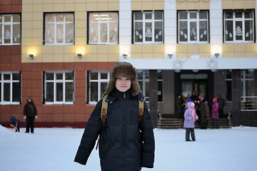 Image showing The boy costs against school in the winter