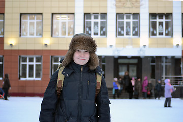 Image showing The boy costs against school in the winter