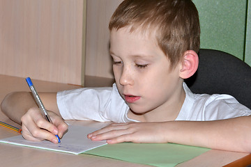 Image showing The boy does homework