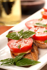 Image showing Bruschetta with tomato, mozzarella and basil with a glass of win