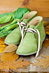 Image showing green leather boots, scarf and yellow leaves 