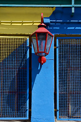 Image showing red street lamp  and a yellow blue wall  in la boca