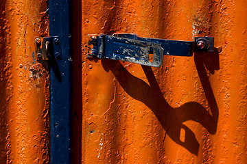 Image showing blue safety lock in a red metal wall