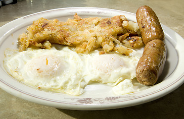 Image showing fried eggs over easy pork sausages home fried potatoes breakfast