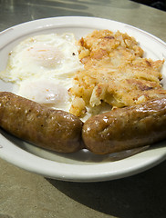 Image showing fried eggs over easy pork sausages home fried potatoes breakfast