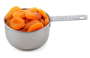 Image showing Whole dried apricots presented in an American metal cup measure