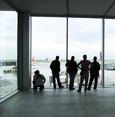 Image showing travel people  silhouette looking at planes on runway in airport