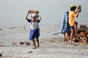 Image showing Child workers carry bricks carrying it on his head in Sonakhali, West Bengal, India