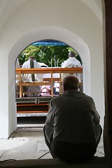Image showing Man sitting at the door of the church