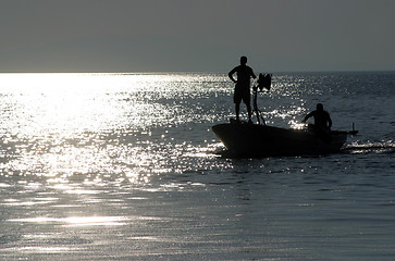 Image showing Boat sailing away at sundown