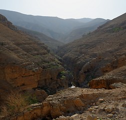 Image showing Counterlight view of desert canyon with flowing creek at the bottom