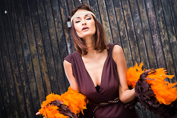 Image showing singing actress in brown and orange boa