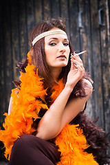 Image showing smoking actress in brown and orange boa