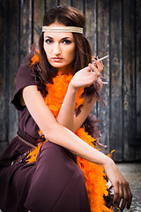 Image showing smoking actress in brown and orange boa