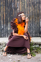 Image showing smoking actress in brown and orange boa