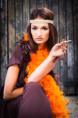 Image showing smoking actress in brown and orange boa