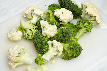 Image showing cauliflower and broccoli pieces on white cutting board