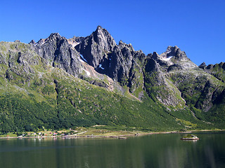 Image showing Sheer mountain peaks and a lake