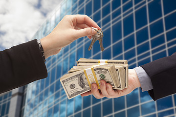 Image showing Handing Stack of Cash For Key and Corporate Building