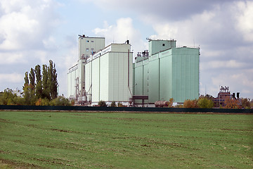 Image showing Grain elevator rises among the fields