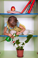 Image showing kid playing and pretending the wardrobe is her home, sprinkling 