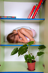 Image showing little girl hugging a toy and hiding in a closet