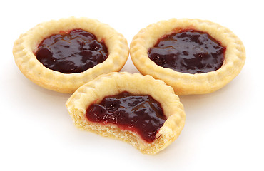 Image showing Three jam tarts, one with a bite taken