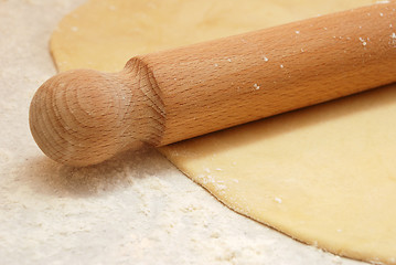 Image showing Detail of a wooden rolling pin on rolled out pastry