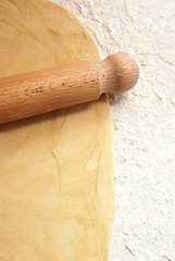 Image showing Portrait image of pastry being rolled out on a floured surface