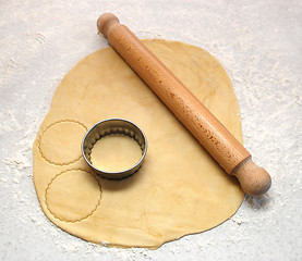 Image showing Rolling pin and cutter on fresh pastry, cutting out circles 