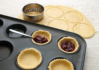 Image showing Cutting and filling pastry shapes to make jam tarts 