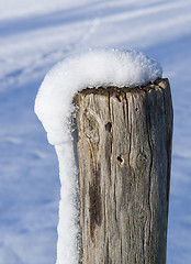 Image showing snowy wooden pole